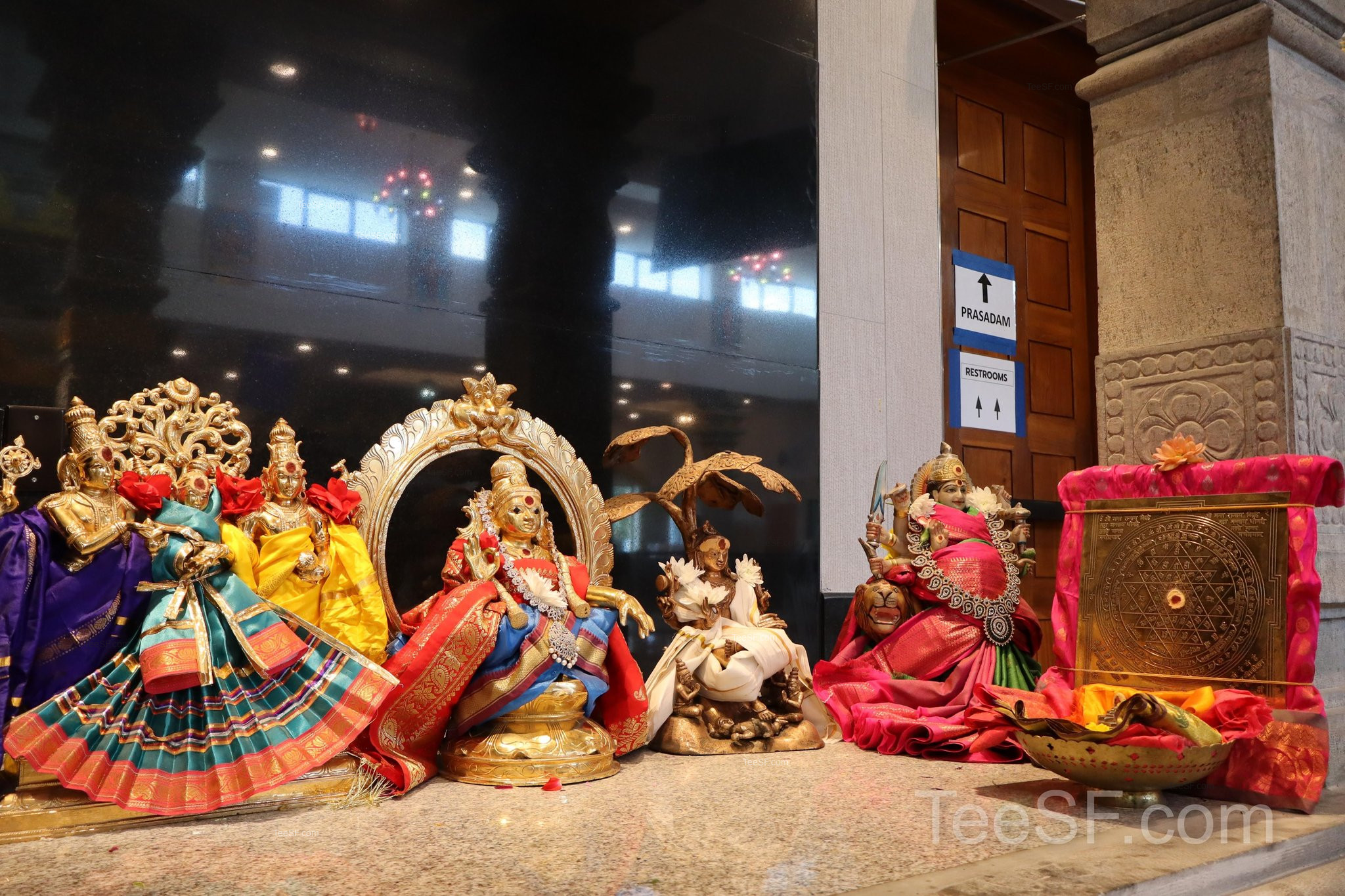 A group of colorful temple figures arranged in a warm shrine setting.